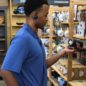 An associate in a retail space using a voice-controlled headset.